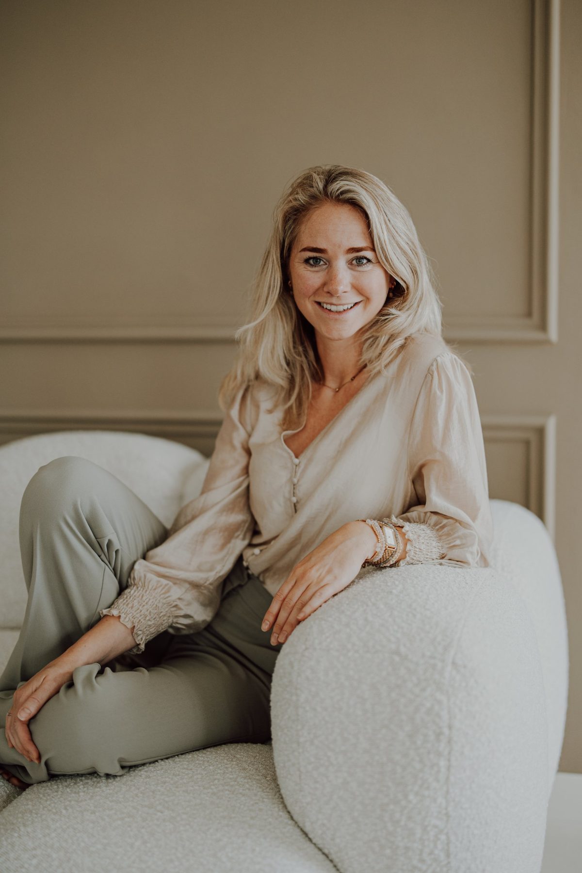 Marlien Groot Bronsvoort, lachend op een witte bank
