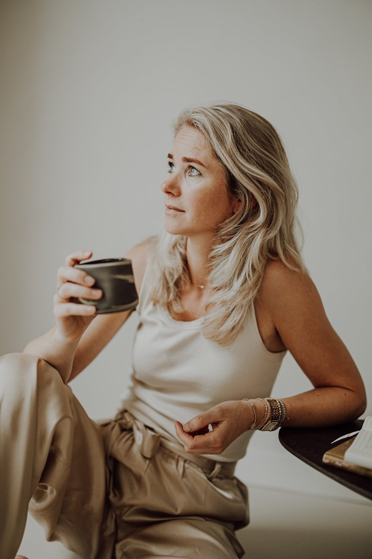 Marlien Groot Bronsvoort met een kop koffie, in gedachten